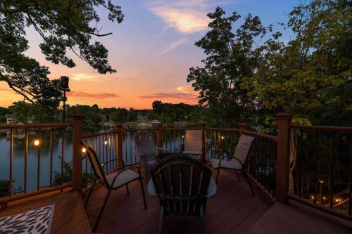 a deck with two chairs and a table with a sunset at Relaxing Lakefront Retreat w/ Hot Tub & Dock in Blountville