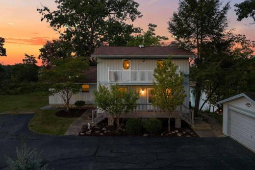 a house with a sunset in the background at Relaxing Lakefront Retreat w/ Hot Tub & Dock in Blountville