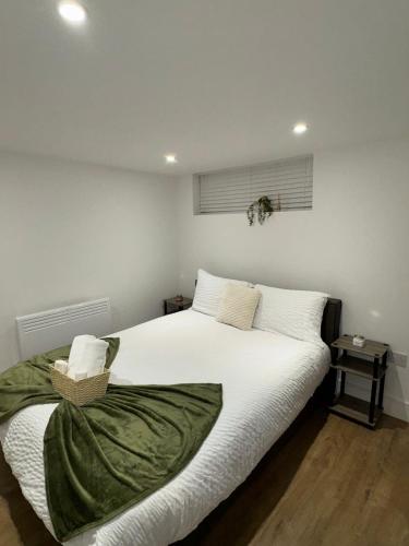 a bedroom with a large bed with white sheets at Spacious 3BR Stay Near Heathrow and Central London in Hounslow