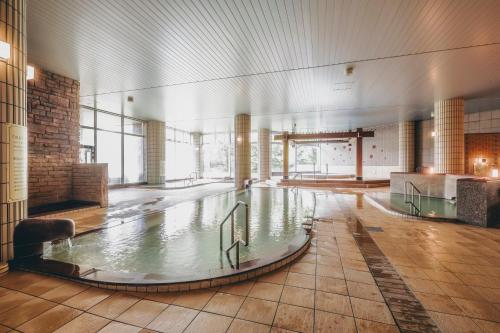 a pool of water in a large room with windows at Oehonke in Kitami