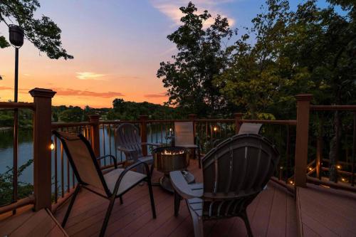 two chairs and a table on a deck at sunset at Relaxing Lakefront Retreat w/ Hot Tub & Dock in Blountville