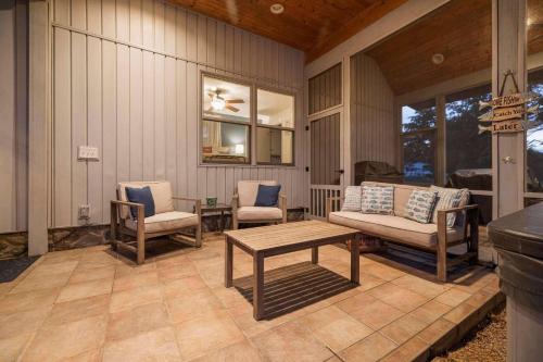 a porch with a couch and chairs and a table at Relaxing Lakefront Retreat w/ Hot Tub & Dock in Blountville