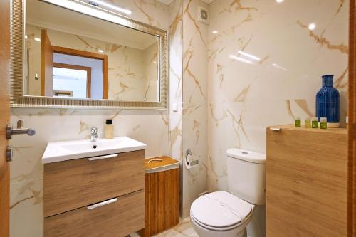 a bathroom with a toilet and a sink and a mirror at Ericeira Sunset Lifestyle II in Ericeira