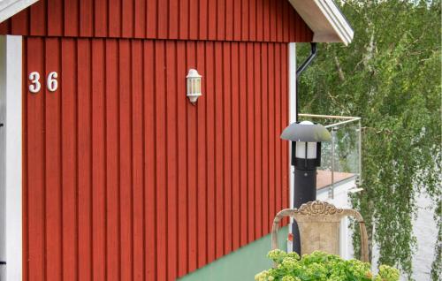 a red building with a light on the side of it at Amazing Home In Vätö With Sauna in Överlöpe