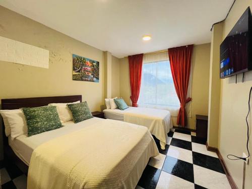 a hotel room with two beds and a window at Mansion del Bosque with Jacuzzi 6 Bedroom 5 Bath in Baños