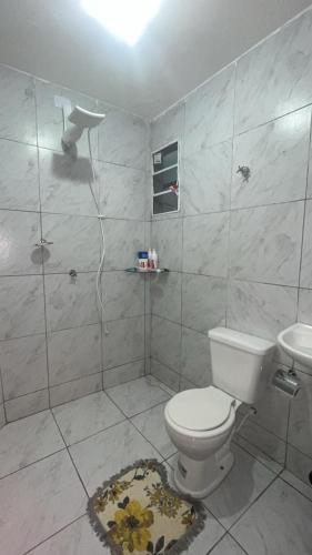 a white bathroom with a toilet and a shower at Apto próx a PRAIA in Paulista