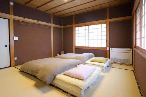 two beds in a room with two windows at Potsupotsuan - Vacation STAY 20035 in Ise