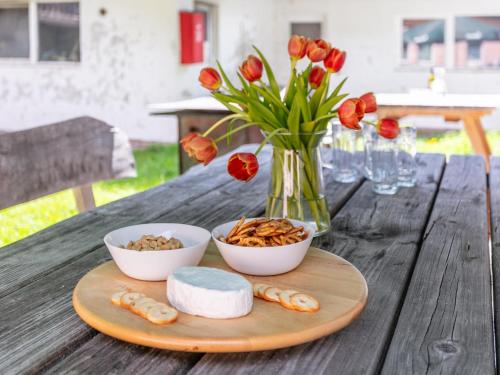 a wooden table with bowls of food and a vase with flowers at Haus Joachim in Winkle