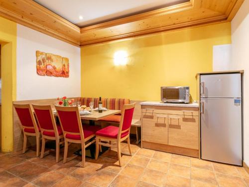 a kitchen with a table with chairs and a refrigerator at Schweizerhof Margrith in Huben