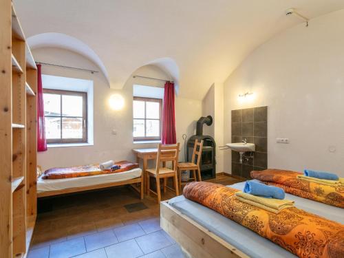 a room with two beds and a table at Schweizerhof Margrith in Huben
