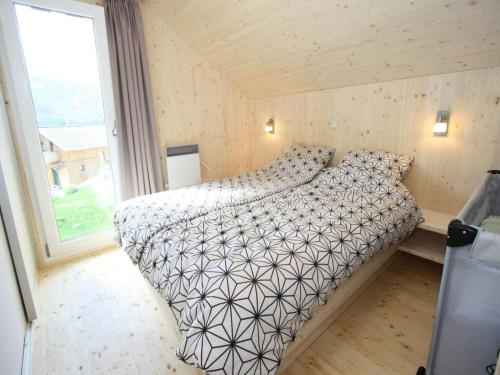 a bed in a small room with a large window at Das Edelweiss in Hohentauern