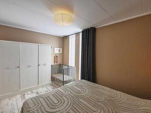 a bedroom with a bed and a crib at Casa Familia in Sint Annaland