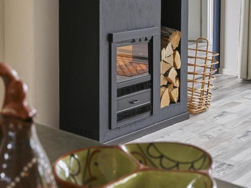 a fireplace in a living room with a stove at Casa Familia in Sint Annaland