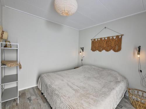 a white bedroom with a bed and a shelf at Casa Familia in Sint Annaland