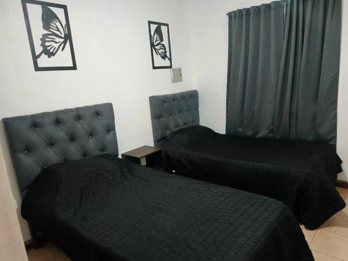a bedroom with two beds and a headboard at Rincón de Lujan in Ciudad Lujan de Cuyo