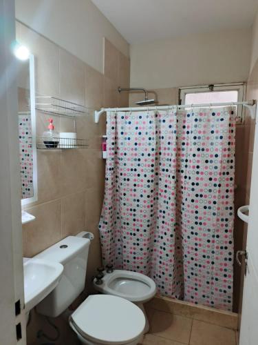 a bathroom with a toilet and a shower curtain at Rincón de Lujan in Ciudad Lujan de Cuyo