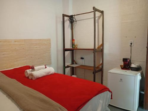 Vila Caraíva Hospedaria في كرايفا: غرفة نوم بها سرير وبطانية حمراء