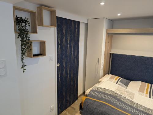 Un dormitorio con una cama con cabecero azul. en Studio aux portes du Puy duFou, en Les Herbiers