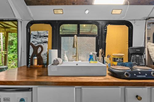 a kitchen with a white sink in an rv at Covered Bridge Tiny Home Bus On The Water In Rrg in Stanton
