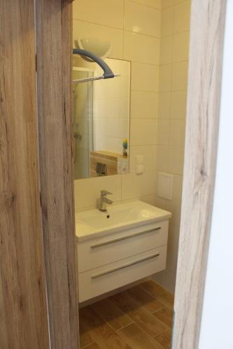 a bathroom with a sink and a mirror at Stara Kamienica Centrum in Mrągowo