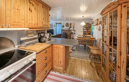 a kitchen with wooden cabinets and a dining room at 3 Bedroom Gorgeous Home In Farsund in Farsund