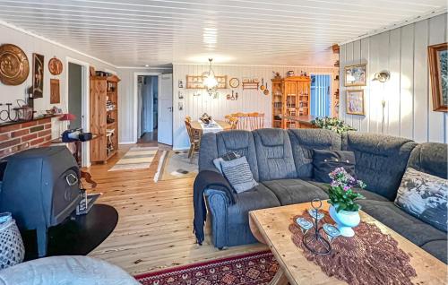 a living room with a blue couch and a table at 3 Bedroom Gorgeous Home In Farsund in Farsund