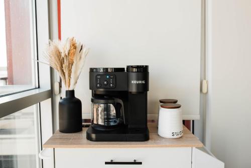 a black coffee maker on a counter with a vase at City Views Walk to Calgary Tower and Stampede in Calgary