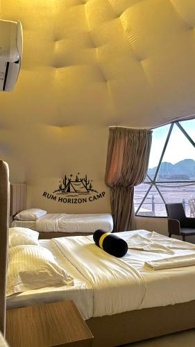 two beds in a room with a sign on the wall at Rum Horizon luxury camp in Wadi Rum