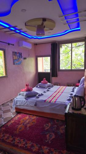 a bedroom with a large bed with blue lights on it at Riad Atlas Garden in Imlil
