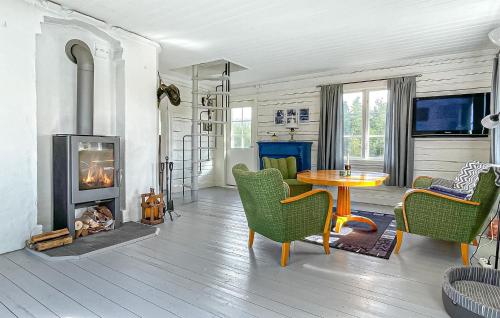 a living room with a table and a fireplace at 2 Bedroom Awesome Home In Töcksfors in Navarsviken