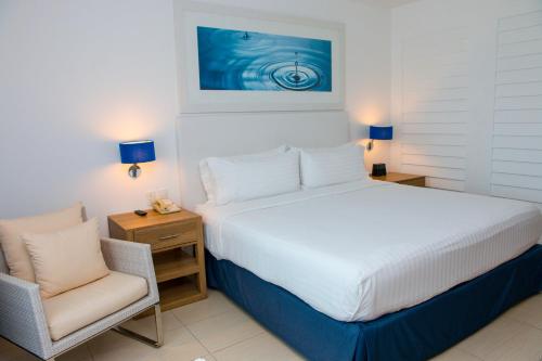 a bedroom with a large bed and a chair at Holiday Inn Acapulco La Isla by IHG in Acapulco