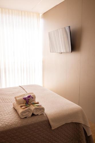 a bedroom with a bed with towels and a window at Apartamento Alto Padrão com Vista Para o Lago in Cascavel