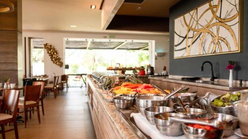 a buffet line with pots of food on a counter at Holiday Inn Acapulco La Isla by IHG in Acapulco