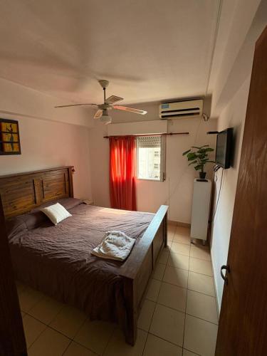 une chambre avec un lit et un rideau rouge dans l'établissement hermoso departamento centrico a 1 cuadra de plaza principal, à San Miguel de Tucumán