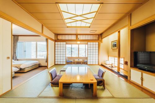a living room with a table and a bedroom at Oehonke in Kitami