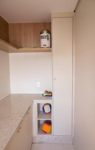 a kitchen with white cabinets and a cupboard at Apartamento Alto Padrão com Vista Para o Lago in Cascavel