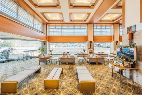 a lobby with couches and tables and windows at Oehonke in Kitami