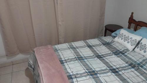 a bedroom with a bed with a blanket on it at Abuelita s in Bajo Boquete