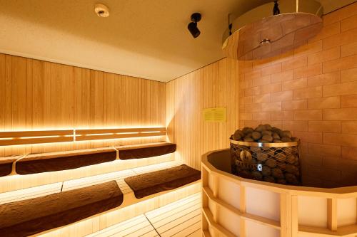 a sauna with a tub with a basket of logs at Oehonke in Kitami