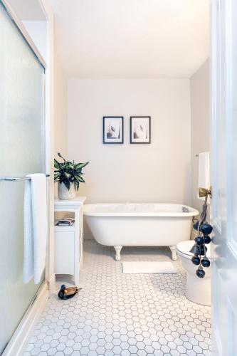 a white bathroom with a tub and a toilet at The Wentworth in Jackson
