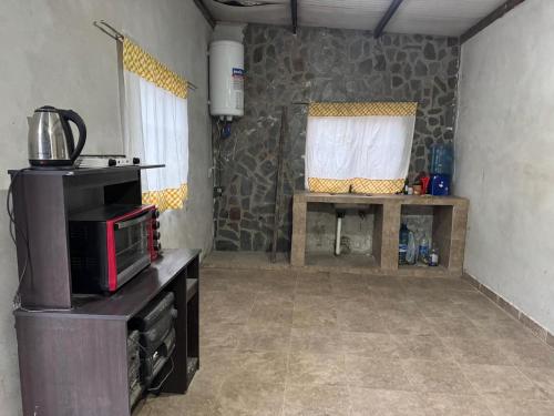 a room with a kitchen with a microwave and a table at Casa Portezuelo in San Javier