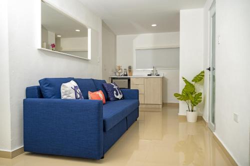a blue couch in a living room with a kitchen at Casa Toñita in Levittown