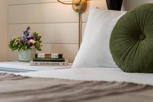 a bed with a pillow and a vase of flowers at The Wentworth in Jackson