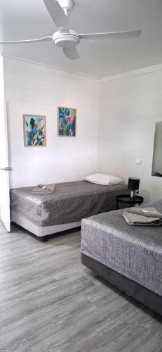 a bedroom with two beds and a ceiling at Burdekin Motor Inn in Home Hill