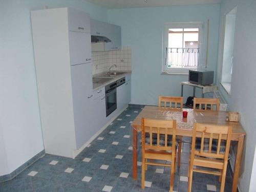 a kitchen with a table and chairs and a kitchen with a sink at Holiday apartment in Ramsberg