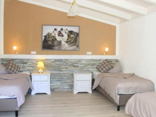 a bedroom with three beds and a brick wall at Holiday apartment in Heretsried with sauna in Heretsried
