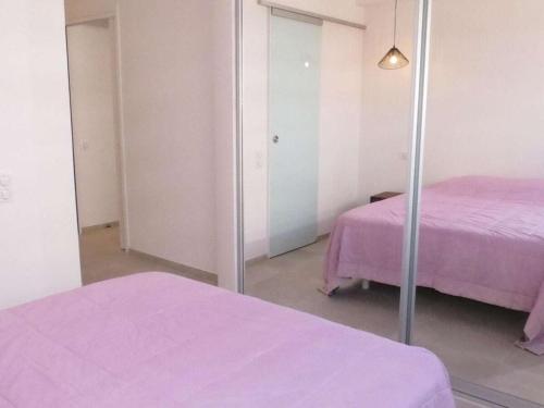 une chambre avec 2 lits et un miroir dans l'établissement Palais de la Mer 233, à Sainte-Maxime