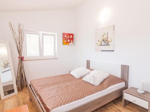a bedroom with white walls and a bed with two pillows at Villa in Pula 42 with swimming pool in Peroj