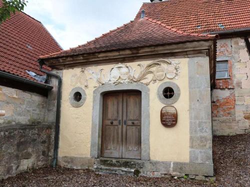 an old building with a door and a sign on it at Holiday home with 4 bedrooms in Maroldsweisach