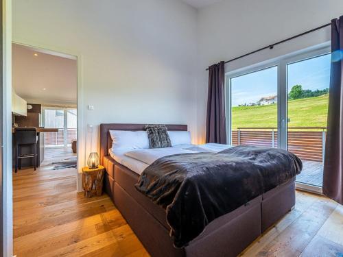 a bedroom with a large bed and a large window at One-bedroom apartment in Kalzhofen